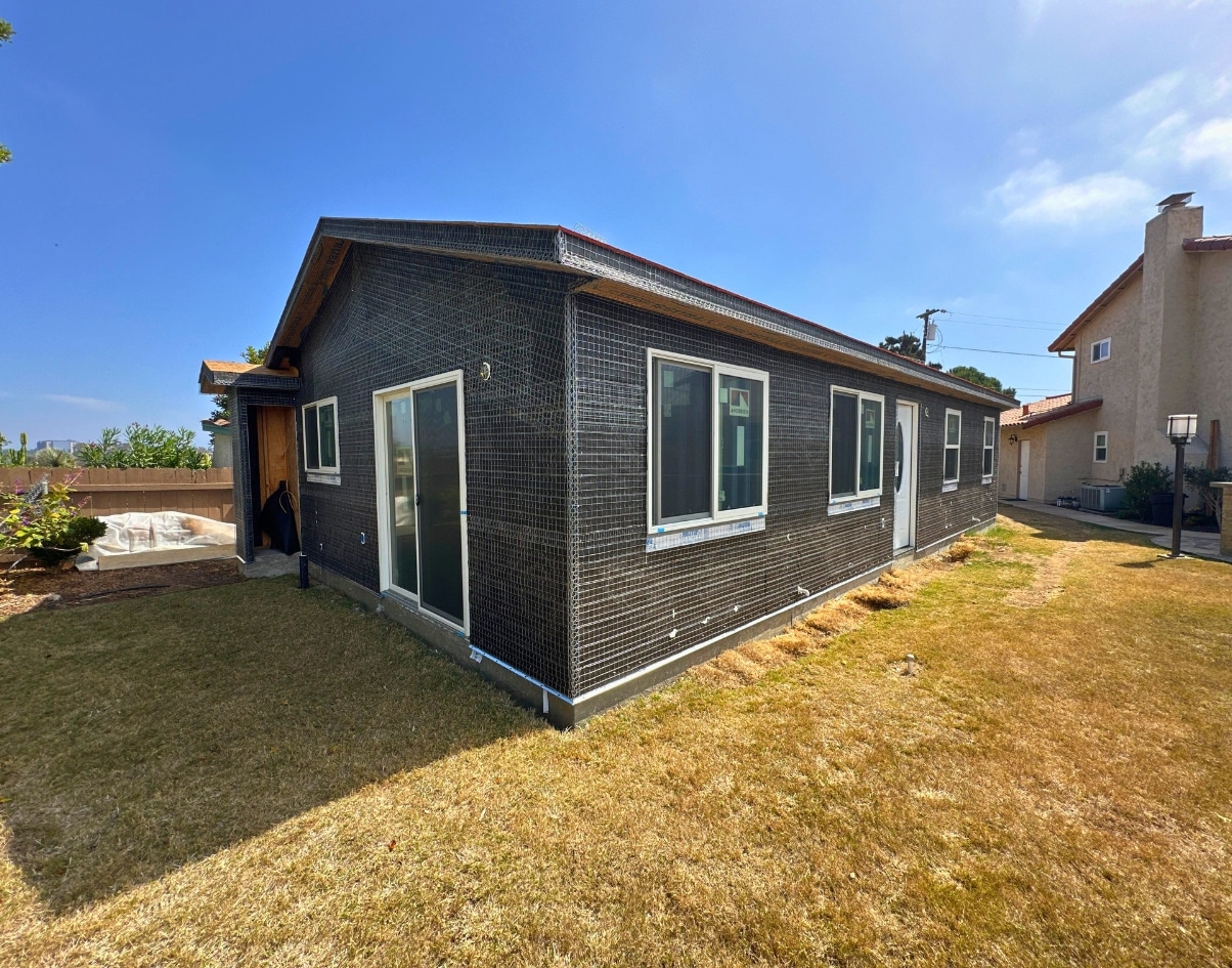 An ADU under construction with black exterior cladding and sliding doors, demonstrating how an ADU cost calculator can help estimate building expenses and manage project budgets effectively.