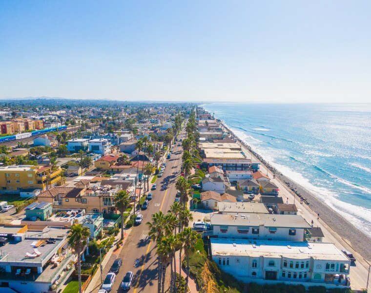 A scenic aerial view of Oceanside, California, showcasing beachfront homes and the surrounding community, ideal for ADU development.