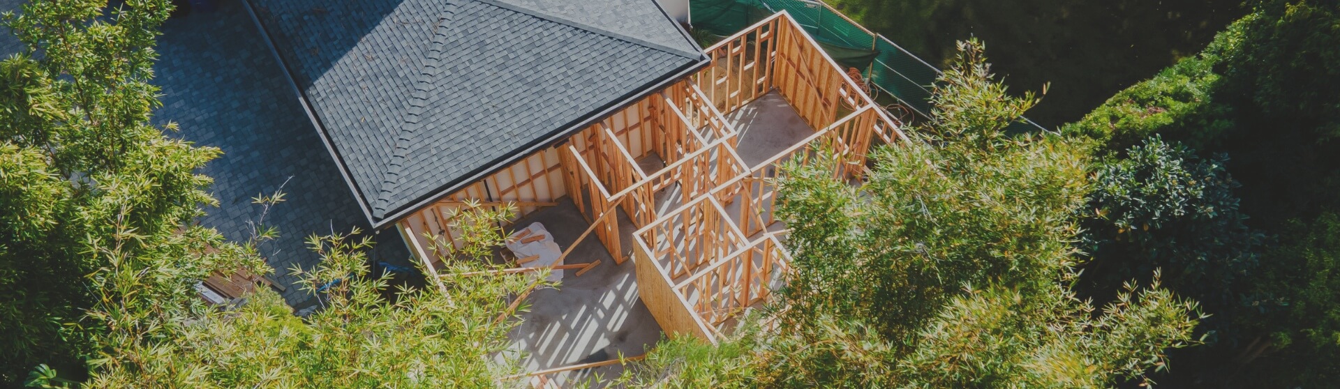 A close-up aerial shot of an ADU under construction, surrounded by lush greenery and a residential setting.