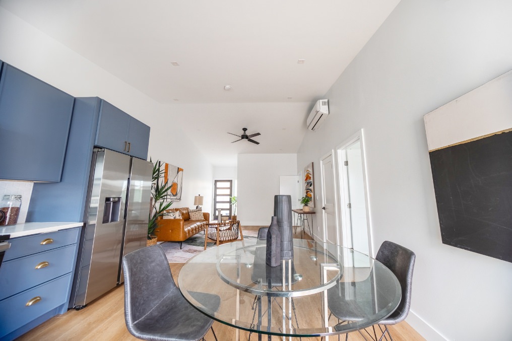 Bright dining area with modern glass table and open floor plan in Pacific Beach ADU.