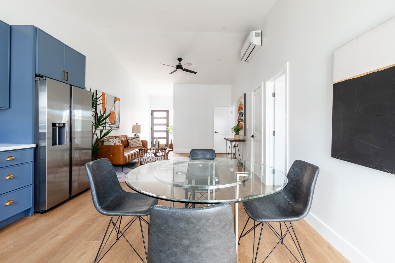 Spacious open-concept dining area with glass table and seamless view into bright living space in Pacific Beach ADU.