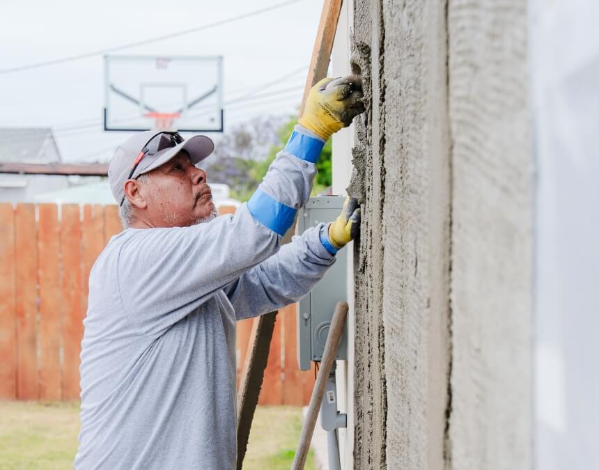 Challenges of Pre-Approved Plans showing exterior stucco work during ADU construction.