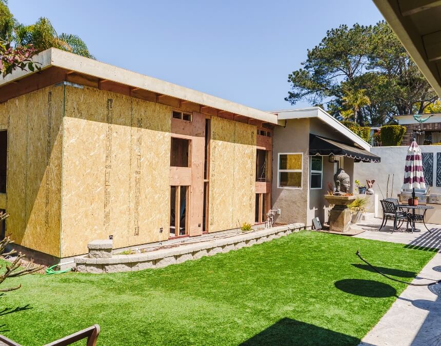 Real Talk Our Recommendation showing partially built accessory dwelling unit construction in backyard.