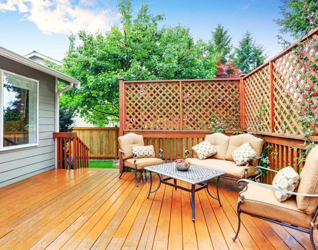 A wooden deck attached to an ADU, furnished for outdoor dining and relaxation.