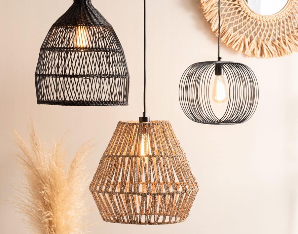 A cluster of unique woven and wire pendant lights hanging in a neutral-toned interior.