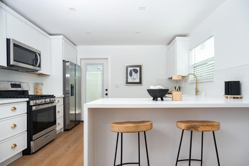 Contemporary kitchen with sleek countertops and wood stools in Clairemont attached ADU