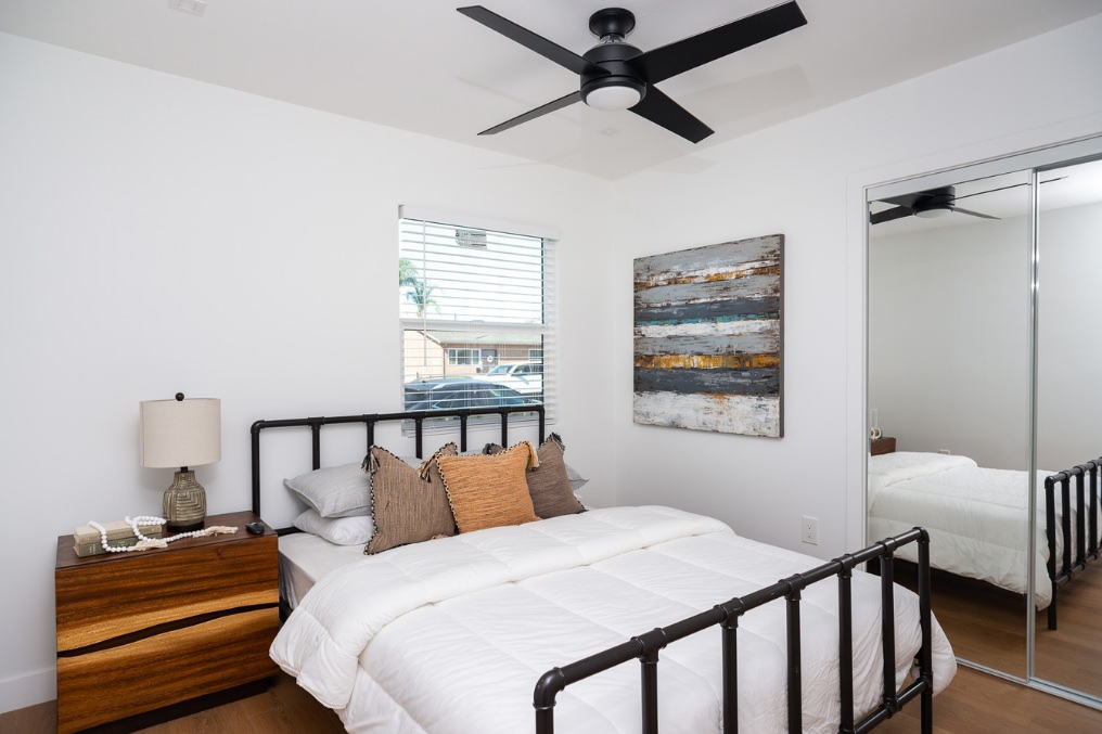 Comfortable guest bedroom with minimalist decor and mirrored closet in Clairemont ADU