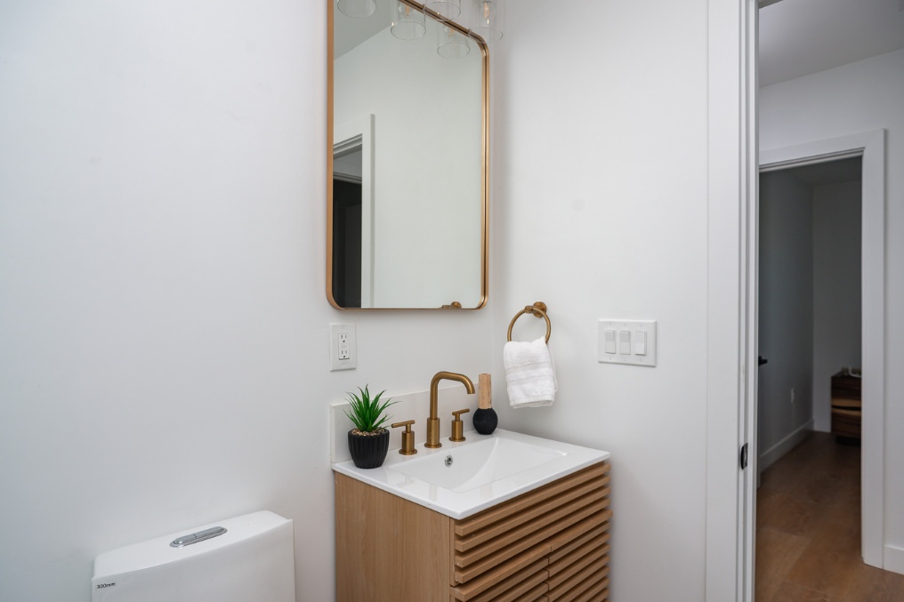 Contemporary bathroom vanity with gold fixtures in Scandinavian-inspired Clairemont ADU