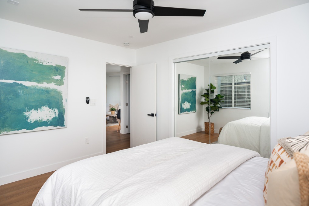 Spacious bedroom featuring large artwork and mirrored closet in Clairemont Scandinavian-style ADU