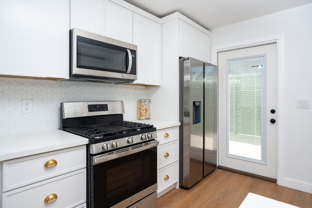 Modern kitchen with stainless steel appliances in Clairemont Scandinavian-style ADU