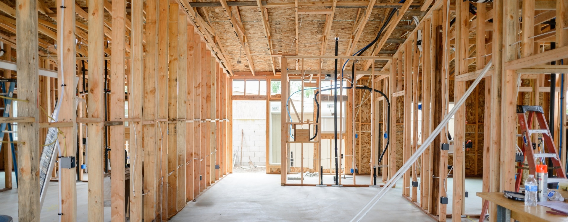 Framed interior of a partially built ADU, showcasing the structural phase of construction with exposed wood framing and initial plumbing work. Highlights the foundational steps required to build an ADU, emphasizing craftsmanship and careful planning.