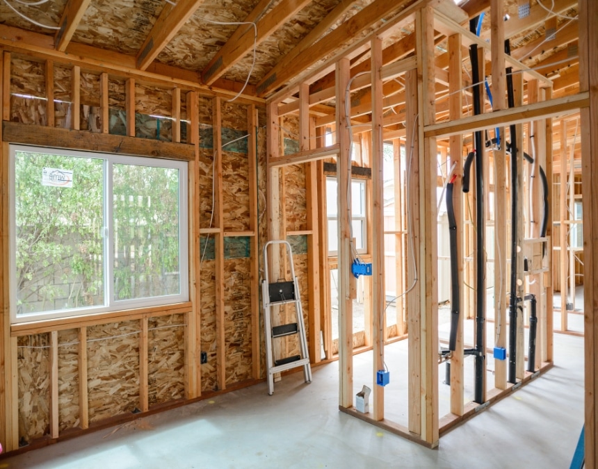 Framed interior of an ADU under construction, showing electrical wiring and utility setup. Addresses the question 'Does an ADU Need its Own Electrical Panel?' by highlighting the preparation for independent electrical infrastructure, which may include a separate panel to ensure safe and sufficient power distribution for the ADU.