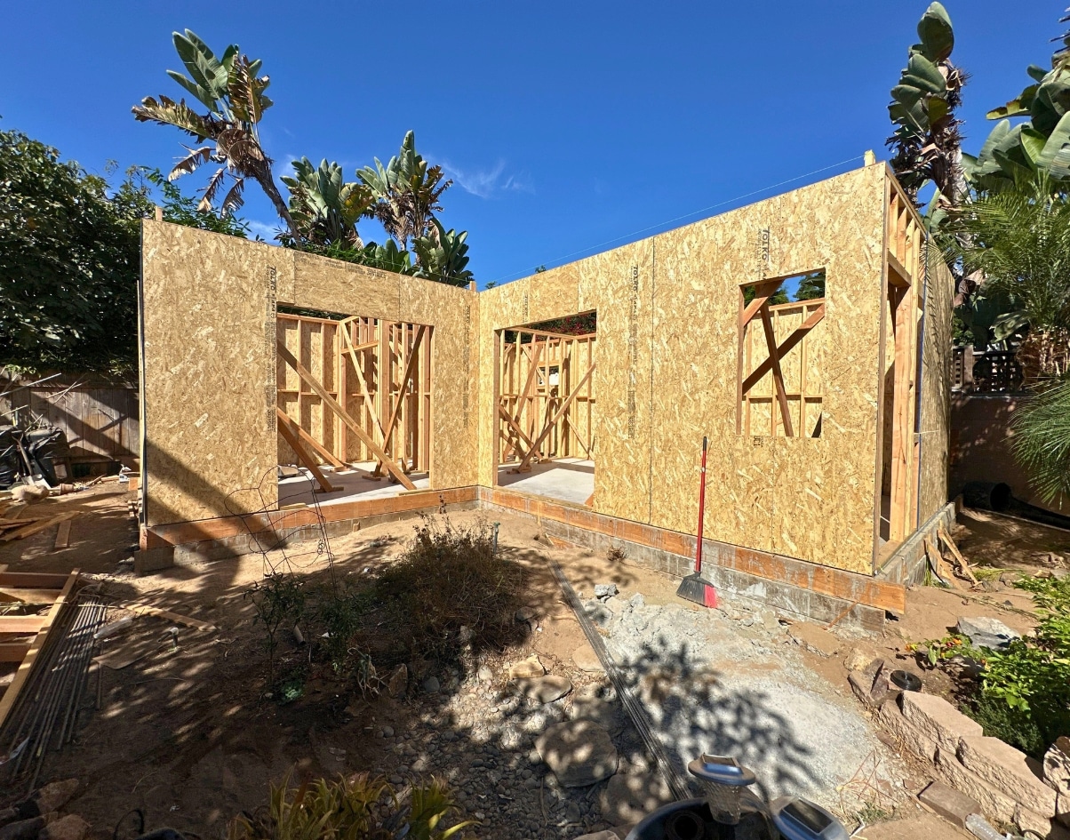 Partially framed exterior of a junior ADU unit in a San Diego backyard, emphasizing early construction stages of this compact living space.