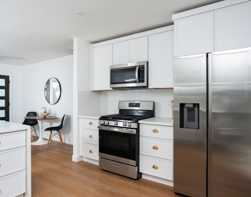 Modern ADU kitchen with essential appliances, including a stove, microwave, and refrigerator, illustrating key electrical components required for ADUs in California. Highlights the importance of proper wiring and power allocation to support major appliances and meet state requirements for safe, functional ADU living spaces.