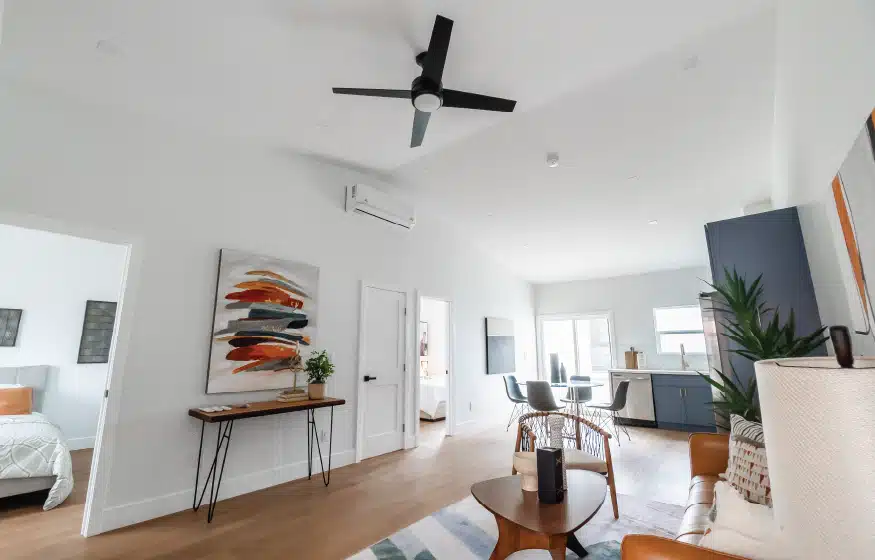 Open-concept living area in a San Diego ADU, featuring modern decor, ceiling fan, and abundant natural light. Highlights the spacious layout and stylish design elements, showcasing a balance of functionality and aesthetic appeal for compact living spaces.