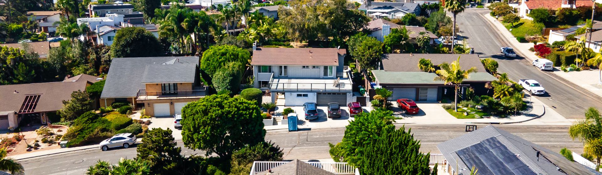 Aerial view of a residential neighborhood showcasing homes with spacious backyards suitable for building guest houses.