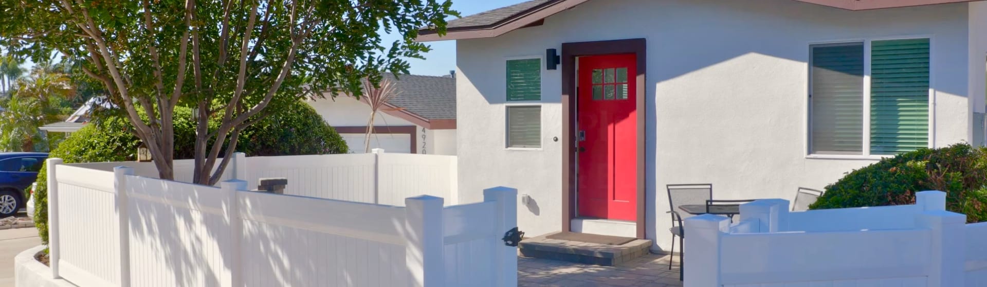 A cozy ADU with a bright red door and fenced-in yard, demonstrating how even a compact unit can enhance both property functionality and curb appeal in California.