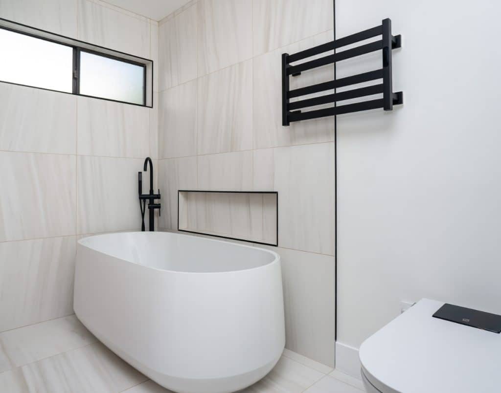 Luxurious ADU bathroom with upscale finishes like a freestanding tub and heated towel rack, showing how premium features can boost rental appeal and income.