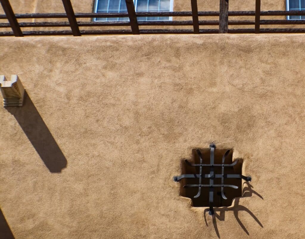 A decorative wrought iron window grille on a Spanish-style ADU.