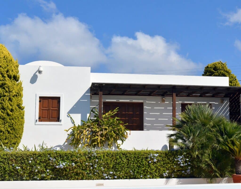 Spanish-style ADU featuring a white stucco exterior with natural landscaping.