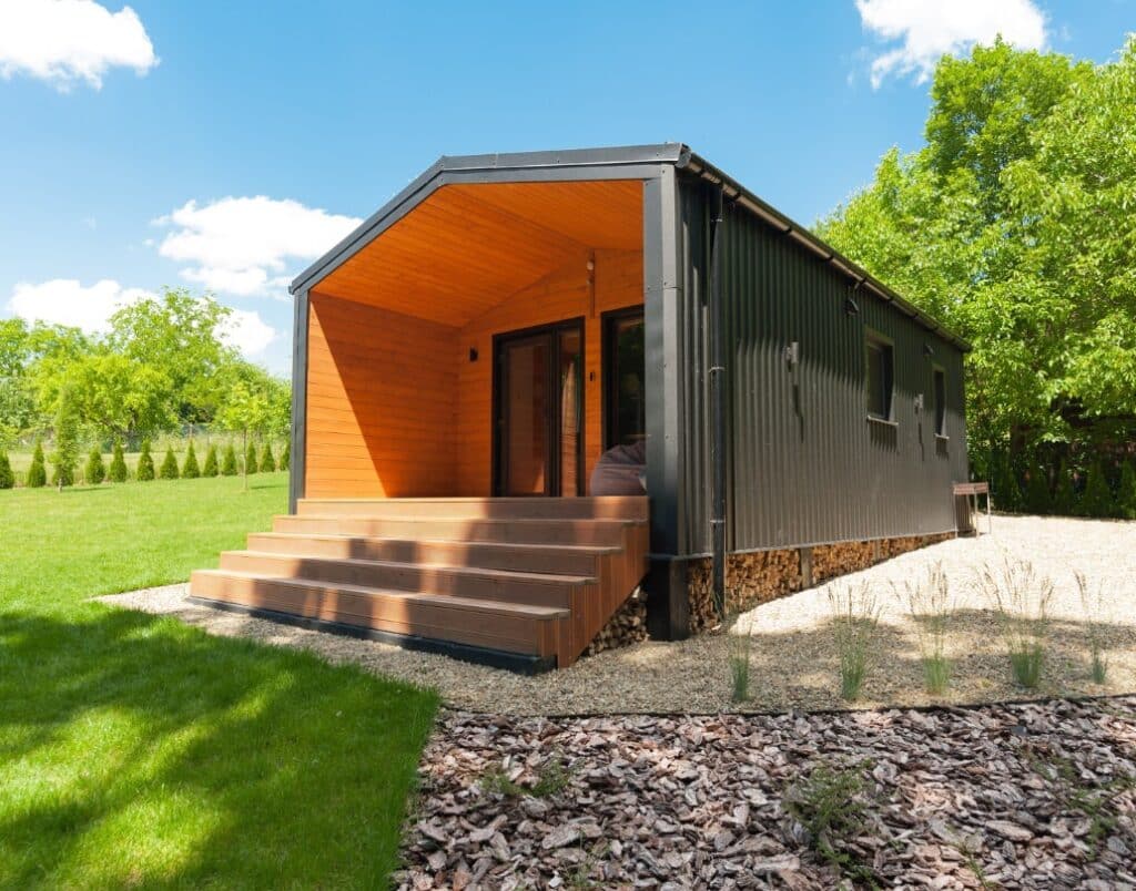 A prefab ADU in a backyard surrounded by greenery, blending in beautifully with its environment.