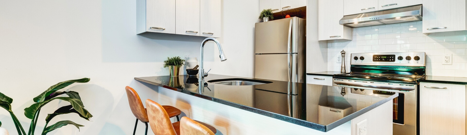 The Perfect ADU Kitchen featuring modern blue cabinetry with gold hardware and stainless steel appliances