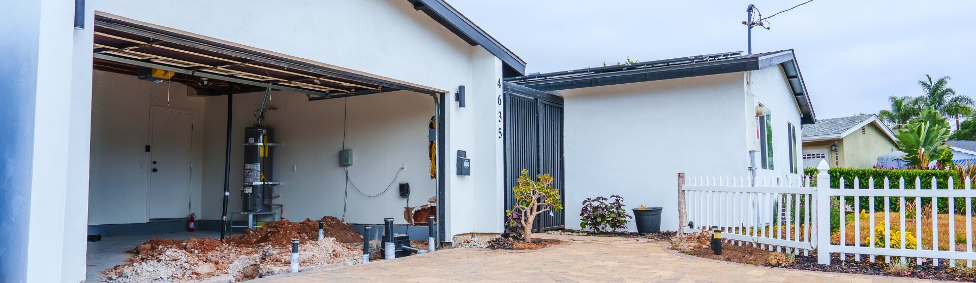 Garage under early construction with exposed trenching and utility lines