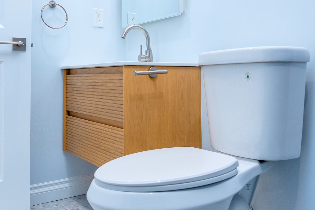 Another view of bathroom featuring wooden vanity, sleek fixtures, and bright, inviting ambiance
