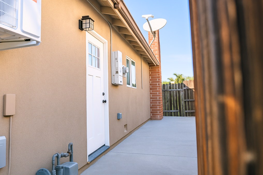 Exterior entrance of coastal-inspired garage conversion ADU with stylish white door and modern fixtures.