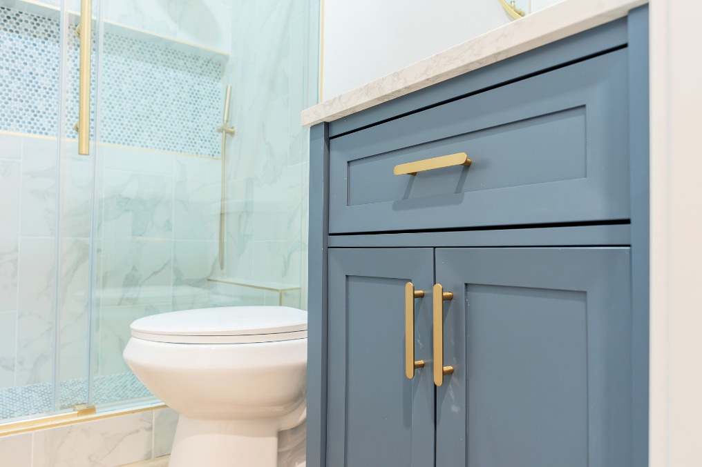 Close-up of contemporary blue bathroom vanity showcasing elegant gold hardware and high-quality craftsmanship.
