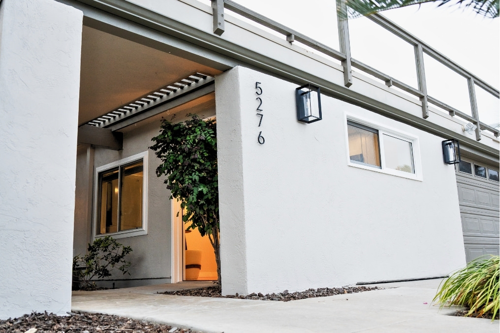 Modern exterior entryway of a stylish garage conversion studio ADU with clean lines, warm lighting, and welcoming greenery.
