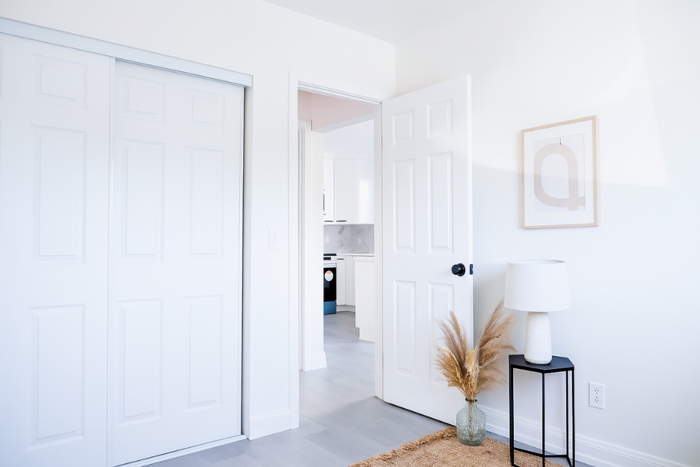 Minimalist coastal bedroom showcasing sliding closet doors and soft interior decor.