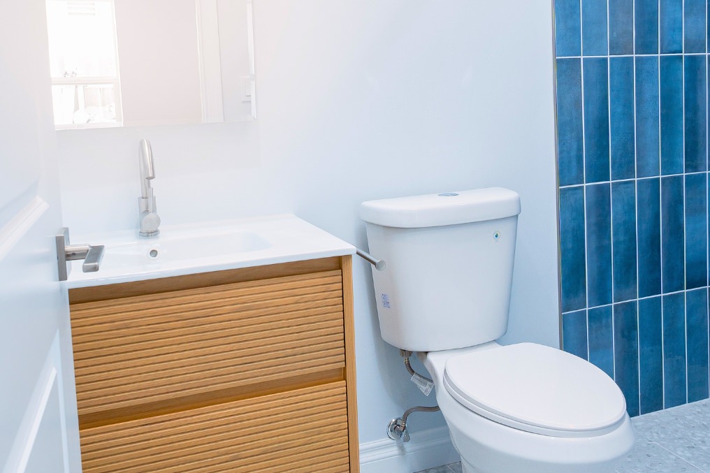Minimalist bathroom with natural wood vanity, contemporary fixtures, and elegant blue tile accents