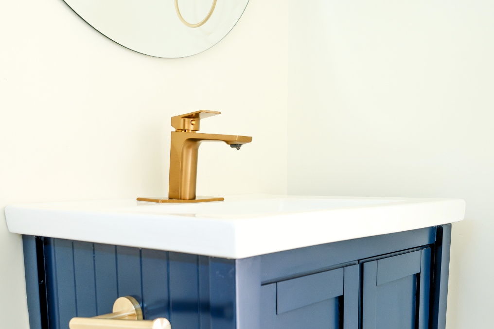 Sleek gold faucet fixture and blue vanity providing a contemporary touch to the ADU bathroom.