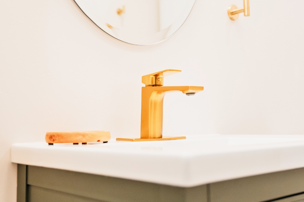 Close-up of elegant brass faucet in modern bathroom vanity at garage conversion studio ADU.