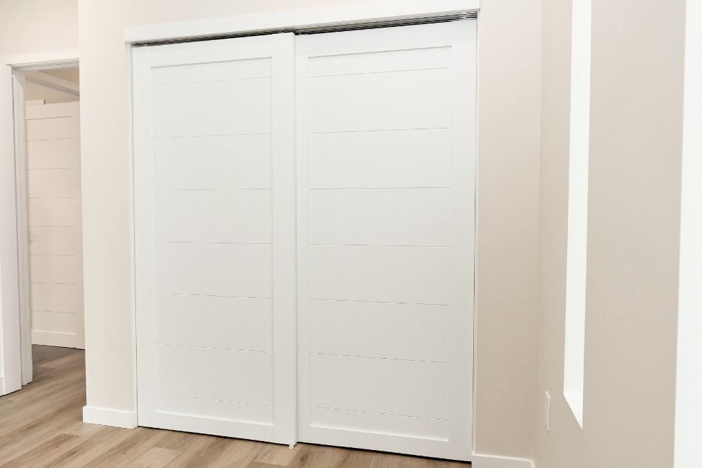 Clean, modern sliding closet doors offering efficient and stylish storage solutions in ADU bedroom.