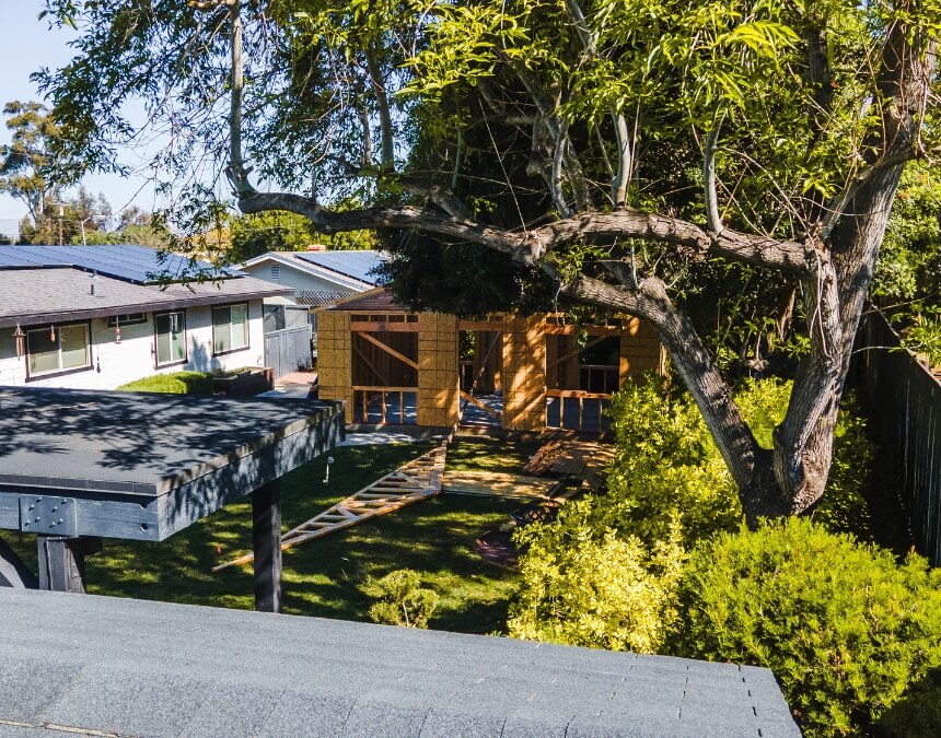 Rooftop view of a solar-paneled home and an active trenching site for new utility connections to an ADU.