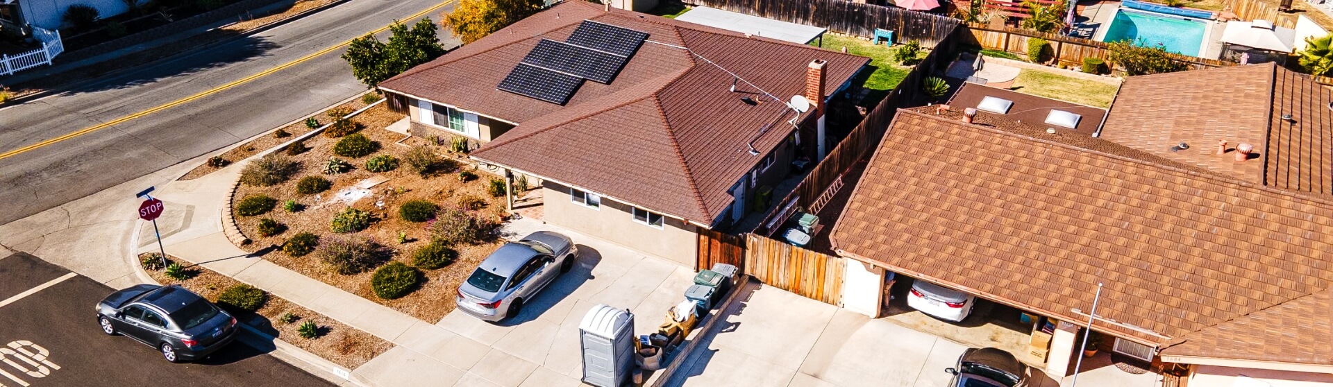 Aerial view of a San Diego residential neighborhood with single-family homes, solar panels, and ample backyard space.