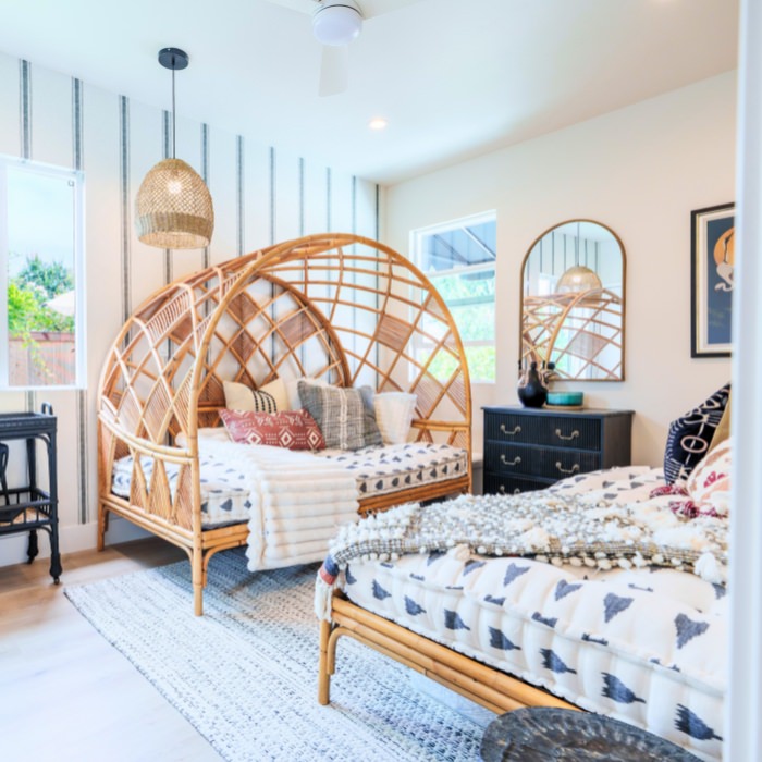 Cozy ADU bedroom with rattan furniture and layered textures designed by San Diego ADU builders.