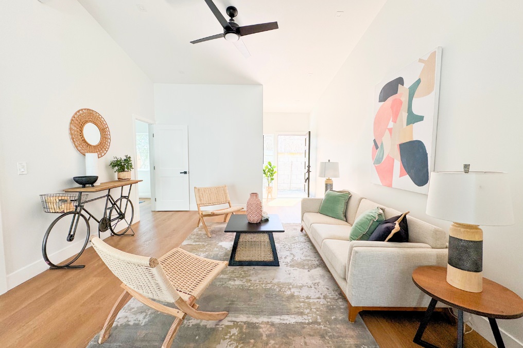 Spacious ADU living room with vaulted ceiling, modern artwork, and layered décor