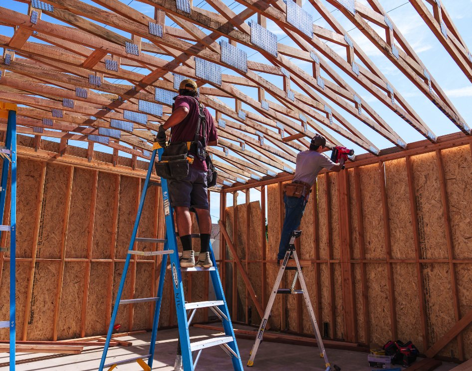 Construction workers building ADU framework illustrating cost factors.