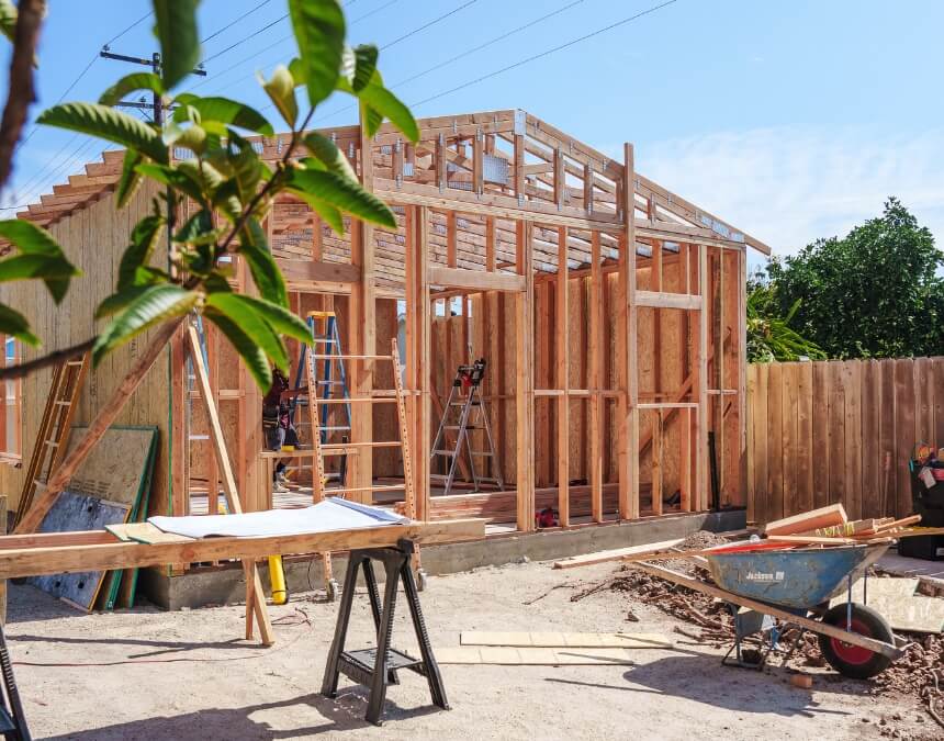 “Types of ADU Builders (Prefab, Custom, Conversion Specialists)” image of a ground-up, site-built ADU framed on a slab in a backyard.
