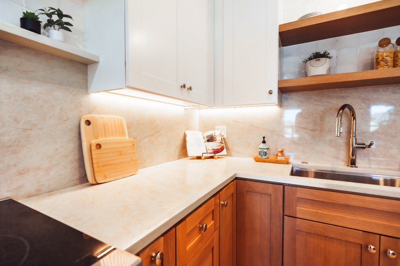 Close-up of the Linda Vista Detached ADU countertops, backsplash, and detailed wood cabinetry with open shelving and under-cabinet lighting.