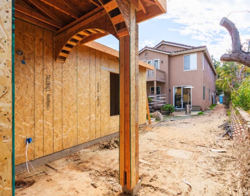Introduction to ADU Project Management – backyard ADU under construction with framing, ladder, and early build stage